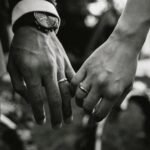 A touching black and white photograph of a couple's hands displaying wedding rings symbolizing love and unity.